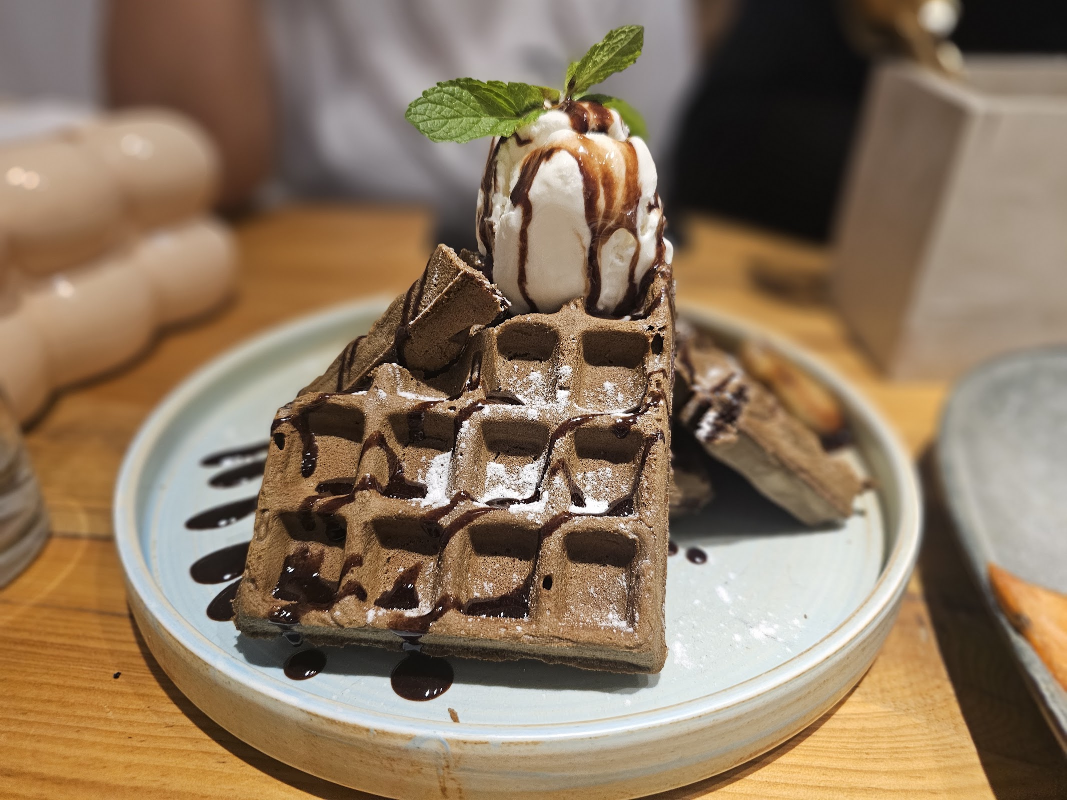 Chocolate waffles topped with vanilla ice cream and mint.